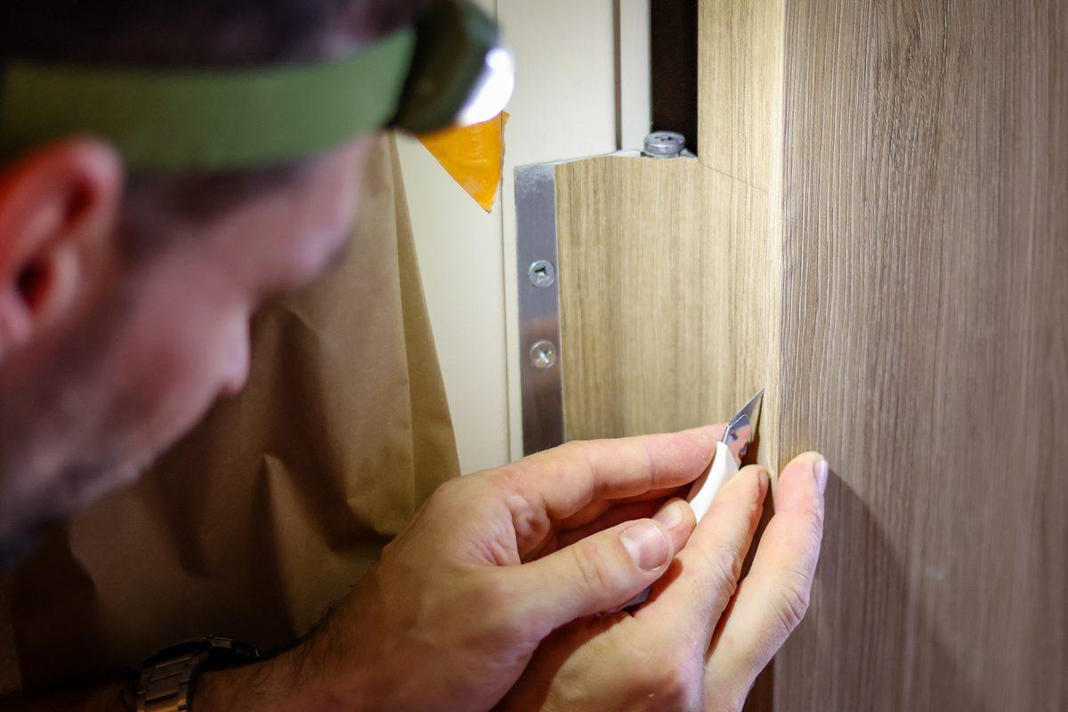 Installer pressing wood-grain film onto a door
