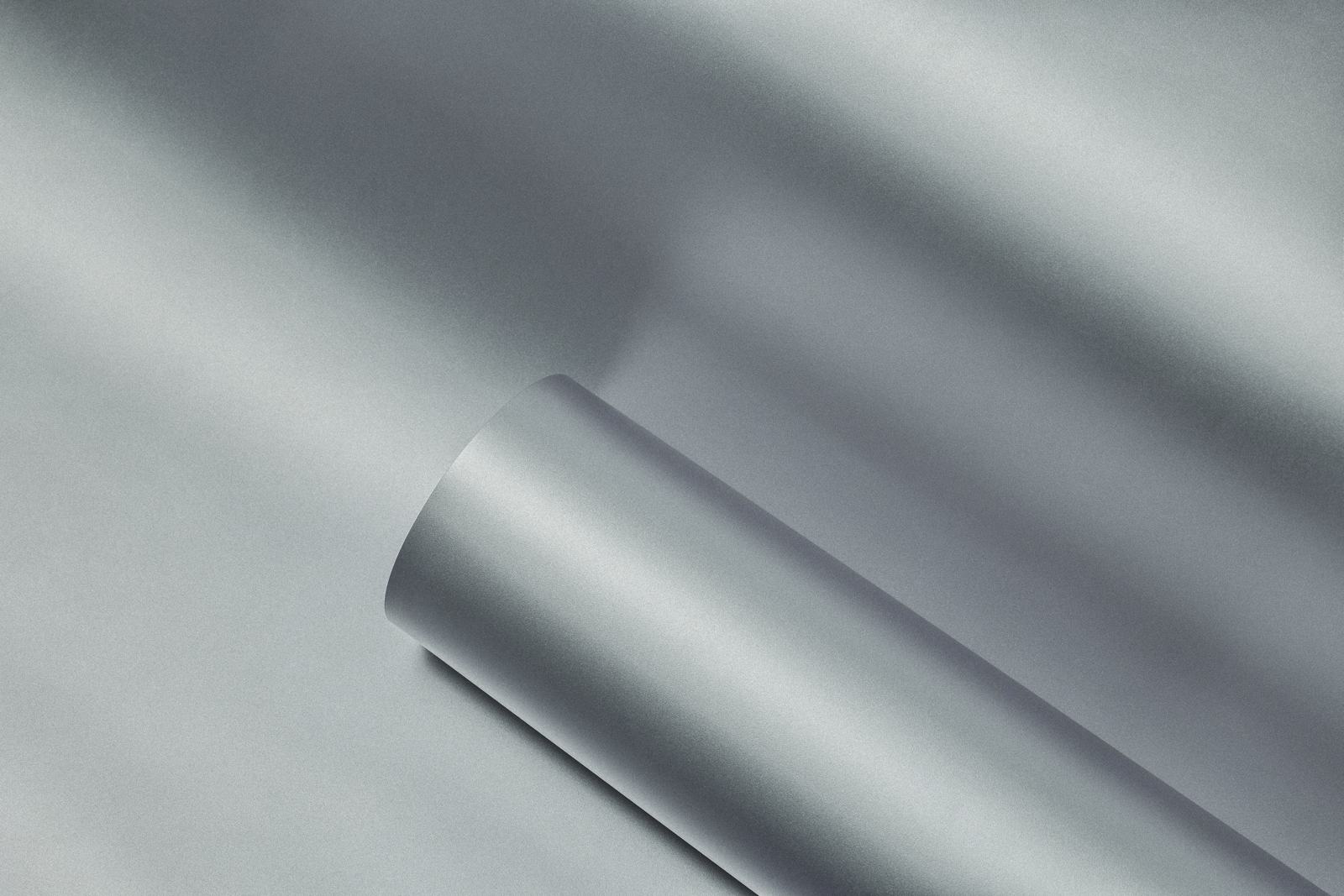 Brushed metal film curling off a roll