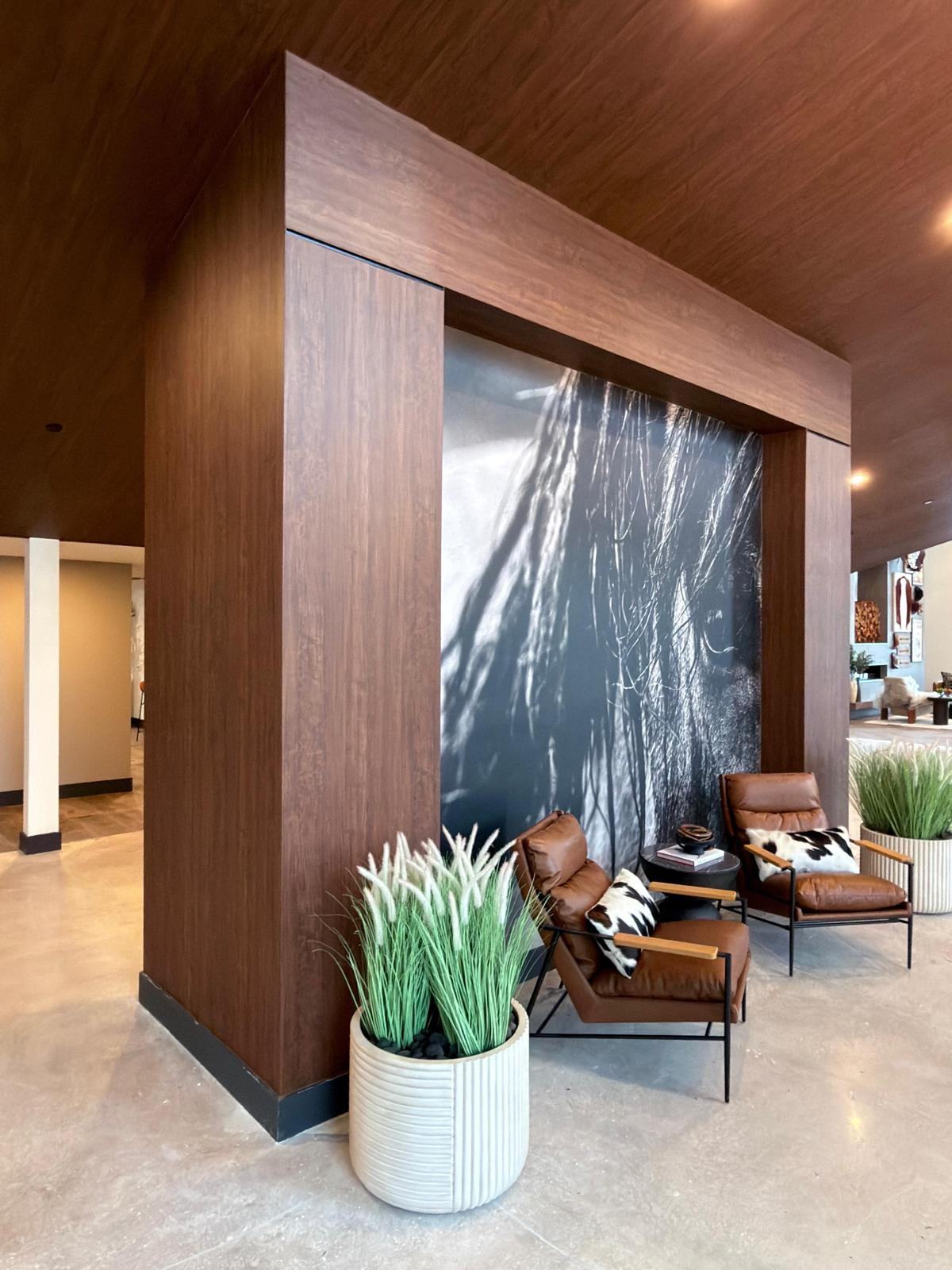 Seating area with a dark wood-look column and lit display shelving